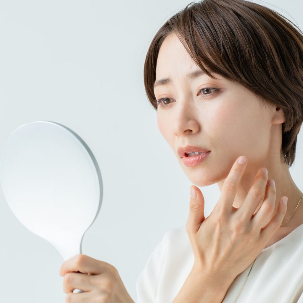 鏡でヒアルロン酸を注入した箇所を確認している女性